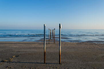 Prospettiva creata dai pali del gasdotto sulla spiaggia del Lido di Venezia in inverno