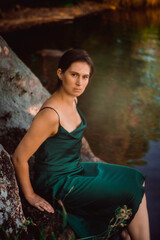 Fototapeta premium Beautiful young girl in an emerald dress in nature