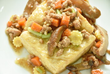 steamed white tofu topping mashed pork and vegetable in gravy sauce on plate