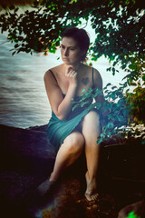 Fototapeta premium Beautiful young girl in an emerald dress in nature