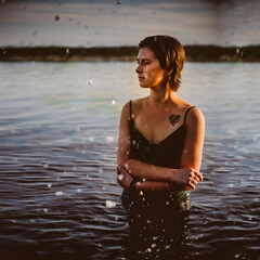 Beautiful young girl in an emerald dress in the water