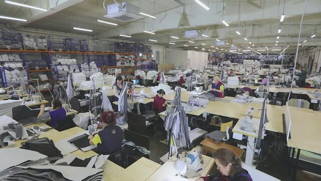 Large sewing production timelapse. There are many seamstresses in the workshop. Garment factory interior. Women in the sewing industry