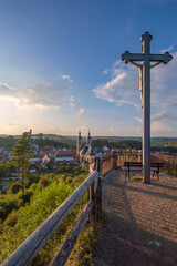 Fototapeta na wymiar Rear view of the cross on the Kreuzberg in Gößweinstein/Germany at sunset with the pilgrimage basilica in the background