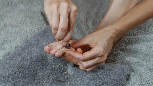 Trimming the cuticles of toenails. Removal of old skin on toes.