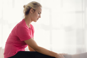 Attractive young woman doing yoga stretching in living room