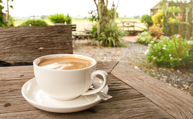 Coffee cup on table with garden view background