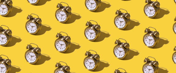 Pattern of an alarm clock on a colored background. Monochrome time concept. Banner format.