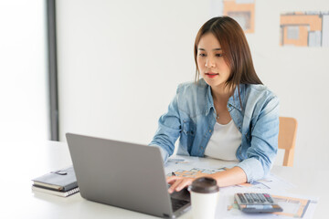 Construction business plan concept, Female architect is drawing house plan of project on laptop