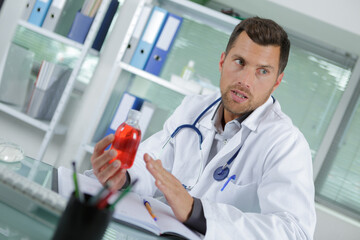 doctor showing bottle of drugs to patient