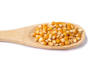 Dried corn or popcorn grains in a spoon isolated over white background