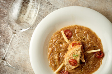 Classic onion soup in a bowl. Close-up. Selective focus. Noise added in post-production