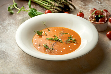 Pumpkin cream soup with jamon and sausages. Noise added in post-production. Selective Focus.