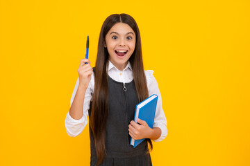 Amazed teen girl. Teen girl pupil hold books, notebooks, isolated on yellow background, copy space. Back to school, teenage lifestyle, education and knowledge. Excited expression, cheerful and glad.
