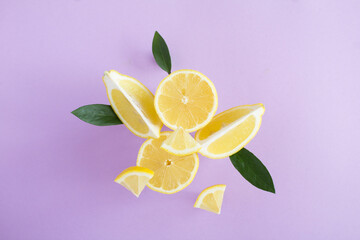 Flying in air fresh ripe whole and lemon with leaves on the purple background. Close-up.