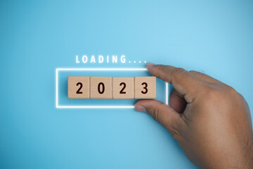 Start new year 2023 setting goal plan, target concept, strategy, new year business vision. Loading 2023 of New Year. Loading bar with wooden blocks 2023 on blue background.