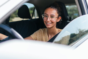 Young smiling woman driving modern car