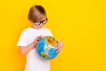 Portrait of handsome curious genius pre-teen boy holding globe explore copy space isolated over...