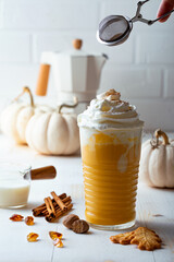 Spicy pumpkin latte with whipped cream. Autumn or winter hot coffee drink with cinnamon, nutmeg and cookies