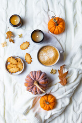 Fall cozy holiday background with cup of coffee, cookies, pumpkins and wool knitted plaid. Warm autumn mood flat lay.  Breakfast in bed