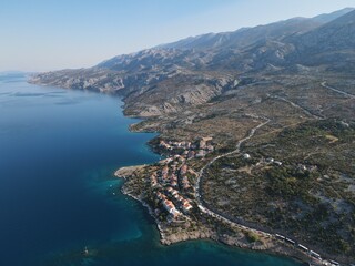 Fototapeta premium Aerial view of Prizna, Trajekt Prizna-Zigljen to reach the island of Pag. Drone view of queue to catch ferry for Pag. Small town with turquoise water on the hill of Croatia, in Dalmatia.