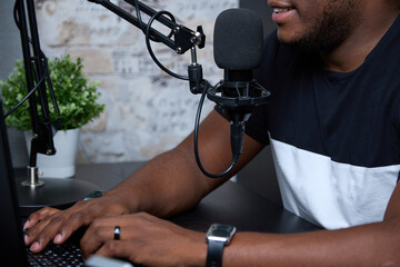 Behind the microphone, a black live host of a popular podcast answers questions from radio...