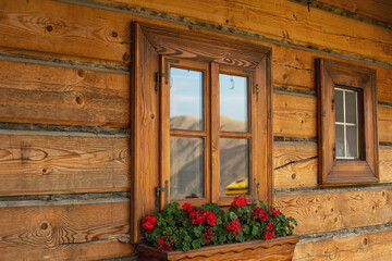 Fototapeta na wymiar Nicely decorated window of a log cabin house.