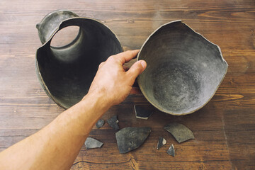 Restoration of broken pottery at excavations. A man collects fragments of a jug.