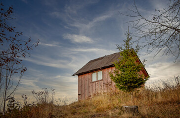 Fototapeta premium Old wooden house or windmill in autumn light 