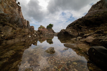 Rocky cliffs, some covered in vegetation, dropping into the ocean