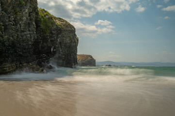 Rocky cliffs, some covered in vegetation, dropping into the ocean