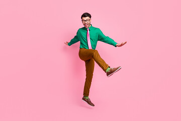 Fototapeta na wymiar Full length photo of sweet charming guy wear green shirt spectacles jumping dancing isolated pink color background