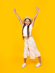 cheerful teen girl in straw hat having fun on yellow background