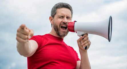man in red shirt shout in loudspeaker on sky background. vacancy