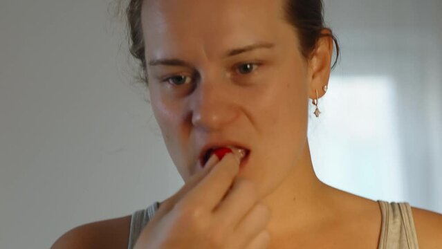 The girl tries dogwood, and winces from the acid. close-up.