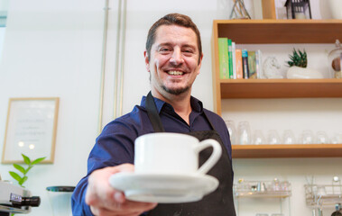 Portrait of a Caucasian man holding a cup of coffee served to a customer