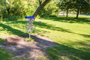 Disc golf, a flying disc sport played using rules like golf, here a disc arrives at a 