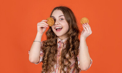 happy teen child with oatmeal cookies on orange background