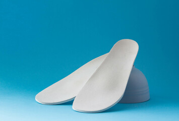 Leather orthopedic insoles on blue background. Prevention and tr