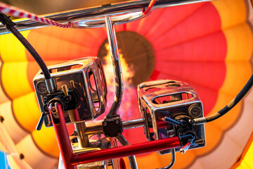 Inside of a colorful hot air balloon as it is inflated for flight, burning burner