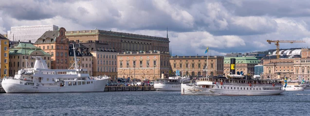 Fotobehang Old commuting steamboat in the bay Saltsjön leaving for the archipelago passing the old town Gamla Stan a sunny autumn day in Stockholm © Hans Baath