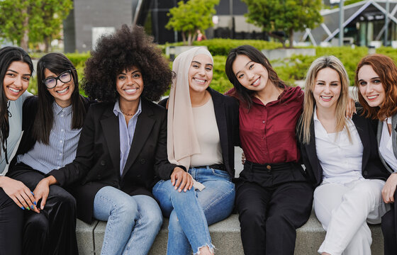 Young diverse business women sitting outdoor while smiling on camera