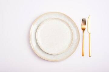 Empty plate with fork and knife on white background. Table setting. Top view, flat lay