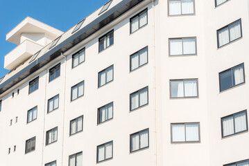 Close-up of the facade of a white building with windows.