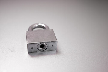Silver key locked on stainless steel background. Lock with keys on stainless steel background.