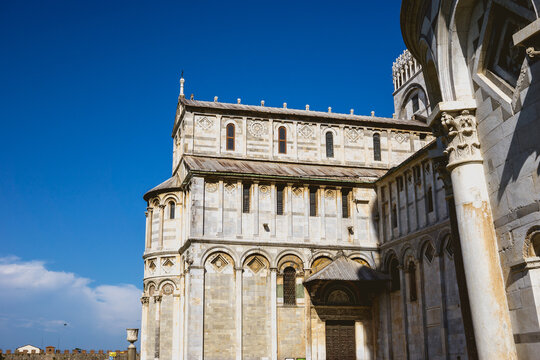 Pisa, Toscana , Italia 08-28-2022.  A picturesque portrait shot of the famous Pisa Leaning Tower on a beautiful day at dusk with a blue sky, and the sun shines on the white marbled campanile.