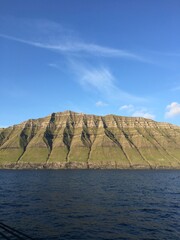 Faroe islands. Beautiful landscape, view from the ocean, blue sky. Panoramic photo