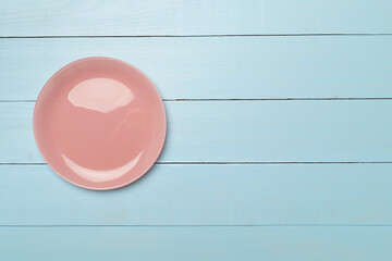 Empty round plate on wooden background, top view