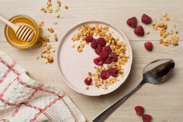 Bowl with granola, yogurt and fresh berries on wooden background, top view