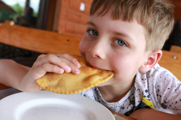 Boy eating adyghe halyuzh pie