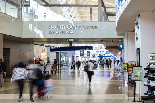 signs in the airport terminal and passengers following them -Los Angeles, United States - February 21 2020